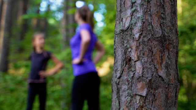 Mom-and-daughter-doing-gymnastics-in-the-forest.