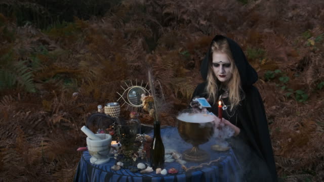 Halloween.-Junge-Hexe-Zauber-am-Tisch.
