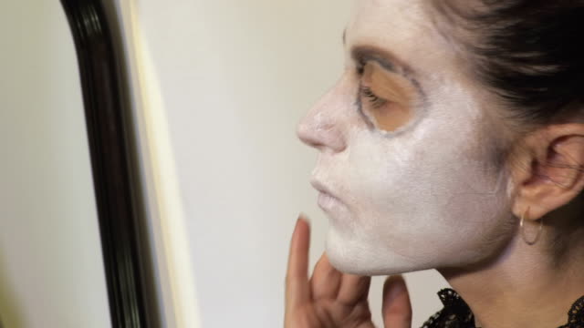Mujer-aplicar-maquillaje-de-Halloween-cerca-del-espejo