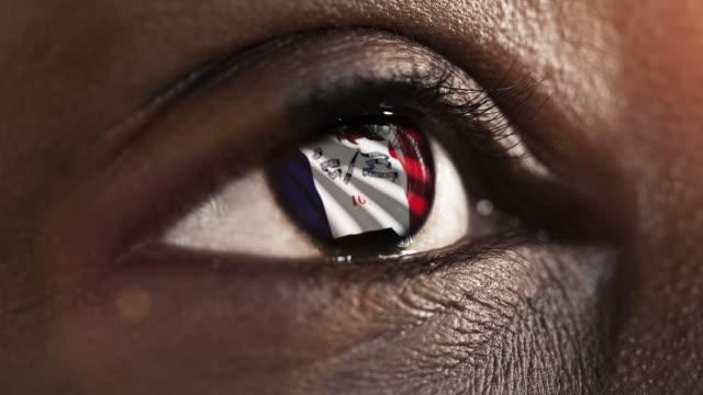 Mujer-ojo-negro-en-primer-plano-con-la-bandera-del-estado-de-Iowa-en-iris,-estados-unidos-de-América-con-movimiento-de-viento.-concepto-de-vídeo