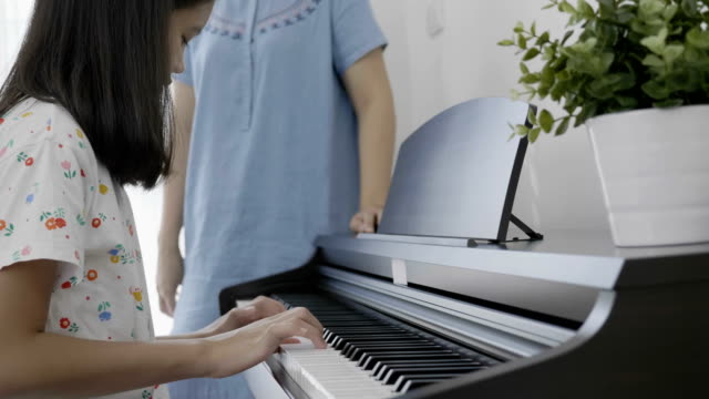 4K:-lenta-de-chica-tocando-el-piano-con-su-madre
