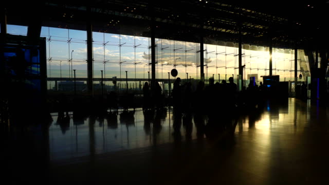 Masse-der-Menschen-Silhouette-zu-Fuß-Kontrast-mit-Morgen-Sonne-Licht-Glasarchitektur-am-Flughafen