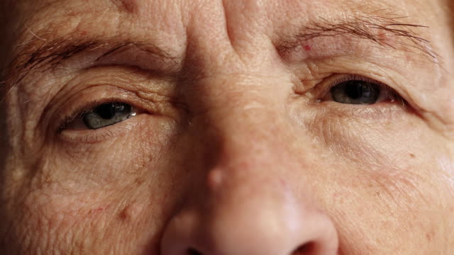 sad-old-woman-opens-her-eyes,close-up-portrait