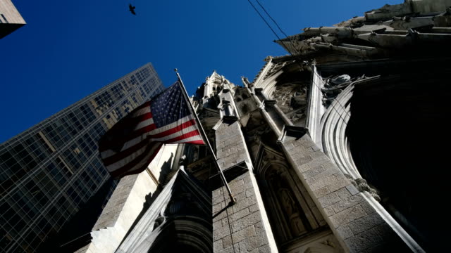 Low-angle-american-flag-fluttering-at-Saint-Patrick-Church-in-New-York