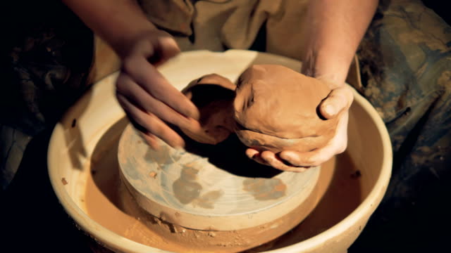 Potters-hands-shape-clay-lumps-over-a-wheel.