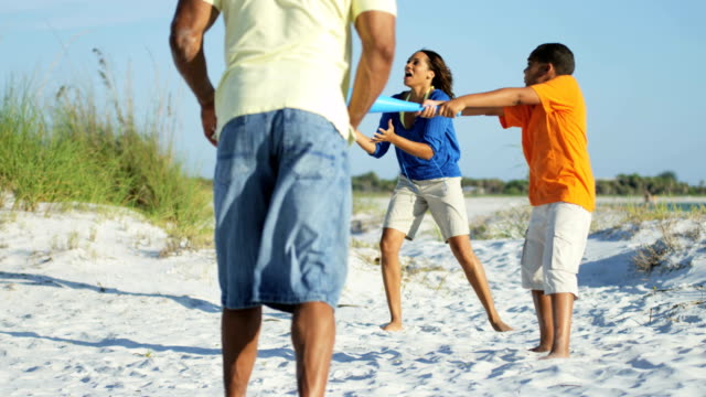 Afrikanische-amerikanische-Eltern-und-Sohn-spielt-am-Strand