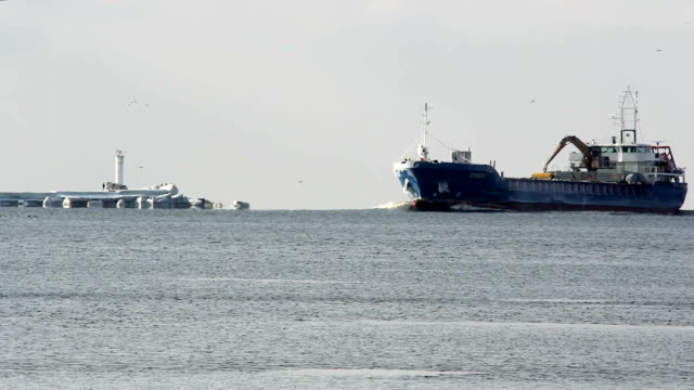 Cargo-ship-with-ports-crane-bridge-coming-in-port