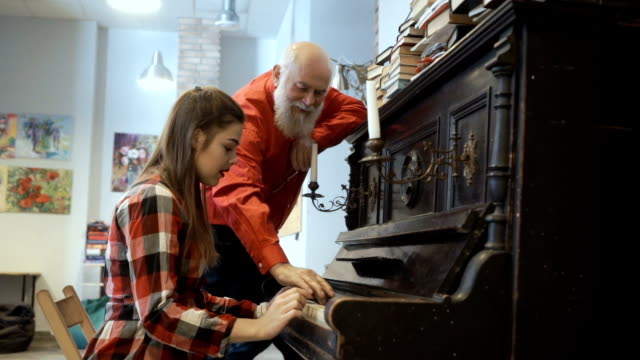 El-abuelo-escucha-nieta-juega-en-el-piano