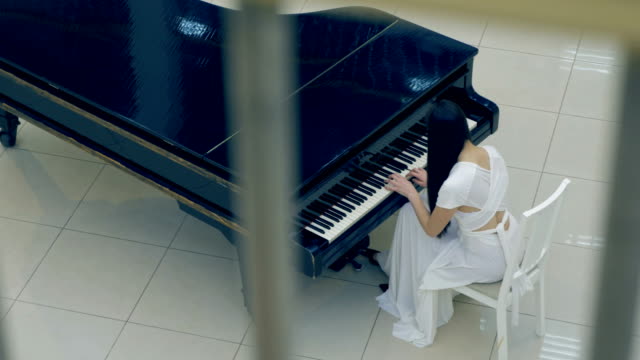 Shooting-from-the-above-of-the-girl-playing-the-piano.-No-face.-4K.