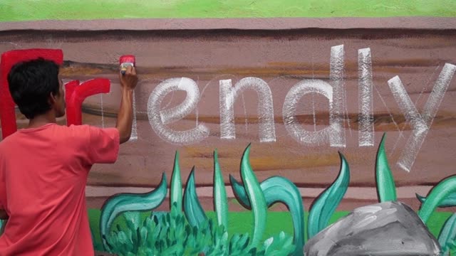 Mural-painter-draws-a-letter-r-on-school-wall.-time-lapse