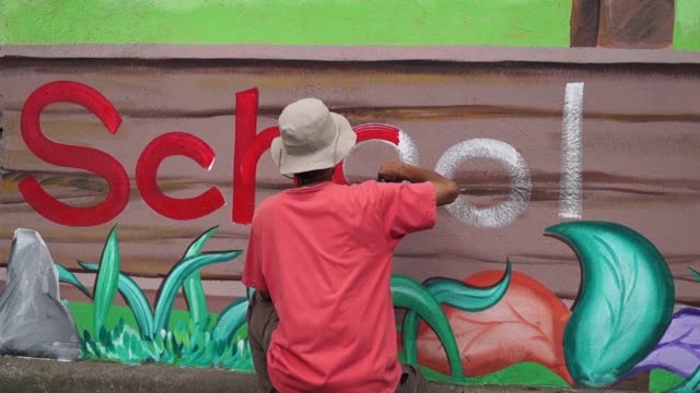 Pintor-mural-dibuja-una-letra-o-en-la-pared-de-la-escuela.-lapso-de-tiempo