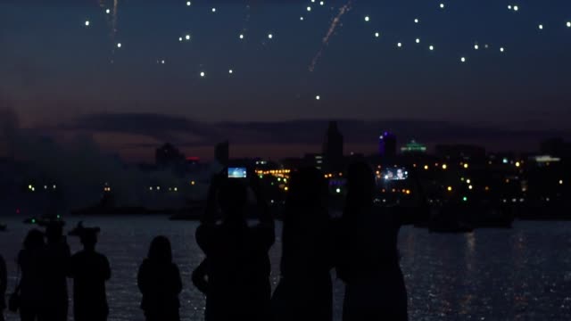 Silhouetten-von-Menschen-während-Feuerwerk-im-Hintergrund-einer-Nacht-Stadt