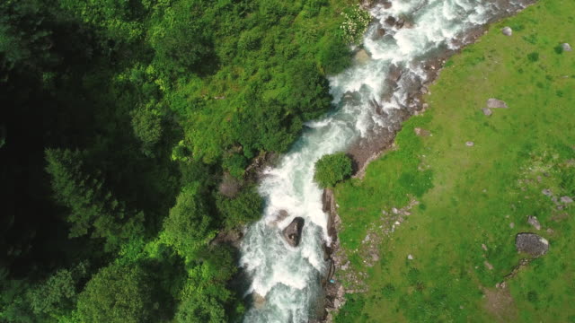 Drone-volando-por-encima-de-la-corriente-en-la-montaña