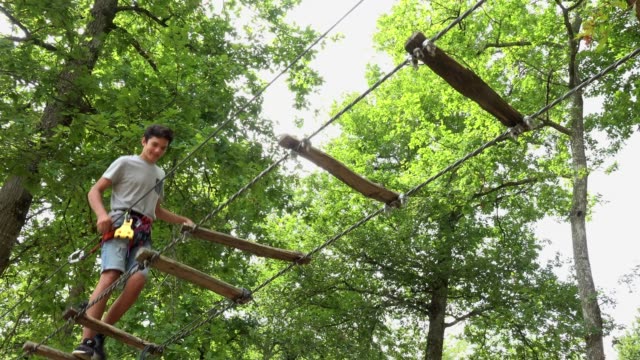 Ruta-de-paso-de-niño-en-Parque-de-cuerda,-mosquetón-de-equipo-de-seguridad-y-cuerdas-para-escalar-árboles-en-Parque-extremo
