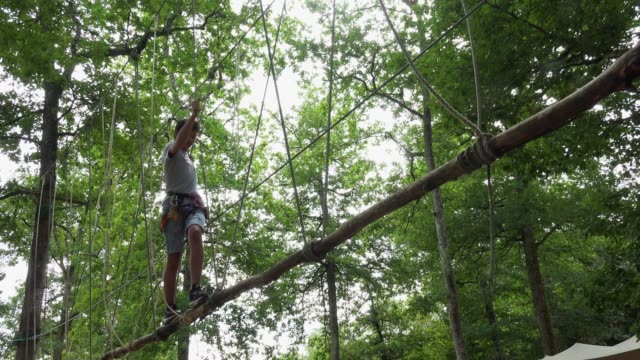 Ruta-de-paso-de-niño-en-Parque-de-cuerda,-mosquetón-de-equipo-de-seguridad-y-cuerdas-para-escalar-árboles-en-Parque-extremo