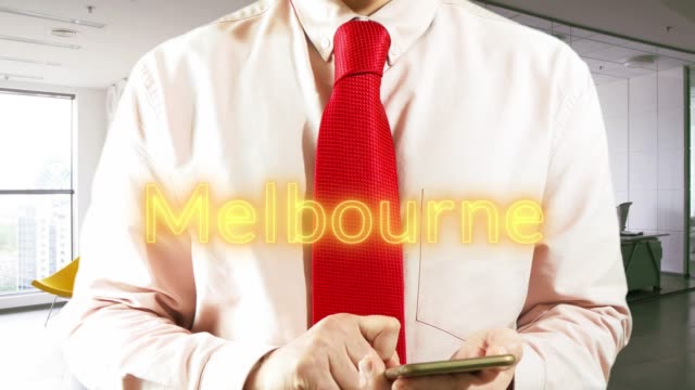 MALBOURNE-Businessman-chooses-а-city-on-virtual-interface-in-light-office.