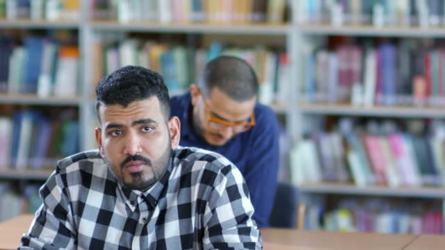 Hombre-árabe-escribiendo-abajo-en-el-cuaderno-en-clase