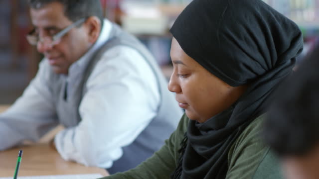 Arabische-Frau-studieren-mit-Gruppe-von-Migranten