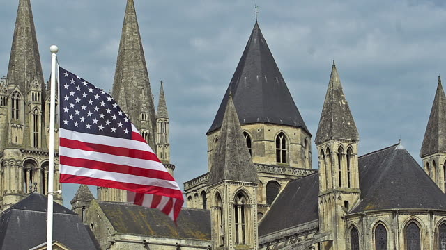Bandera-americana-ondeando-en-el-viento,-la-ciudad-de-Caen-en-Normandía,-cámara-lenta