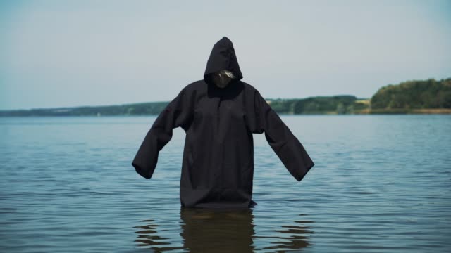 Scary-figure-in-black-mantle-in-the-river.