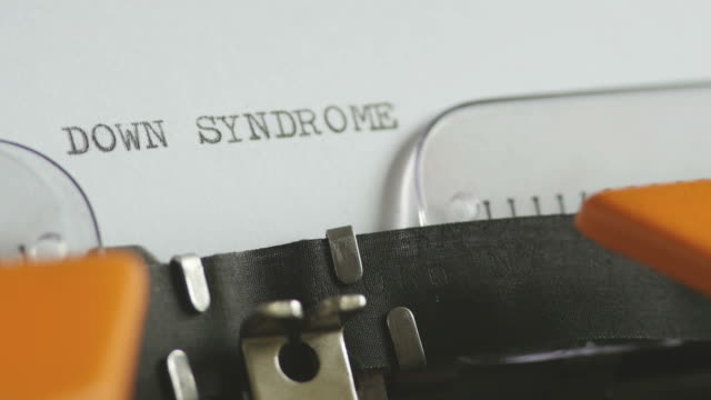 Close-up-footage-of-a-person-writing-DOWN-SYNDROME-on-an-old-typewriter,-with-sound