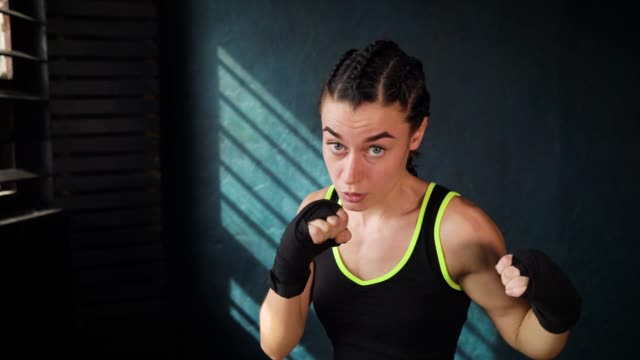 Closeup-Retrato-mujer-hermosa-joven-boxeo-entrenamiento-en-gimnasio-de-perforación