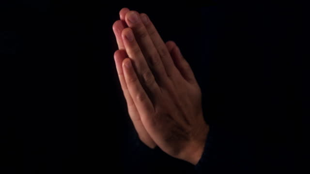 Male-praying-with-hands-clasped