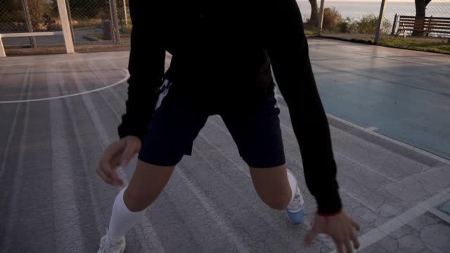 Female-basketball-player-in-morning-light-on-professional-court-running-with-ball.-Handhelded-footage