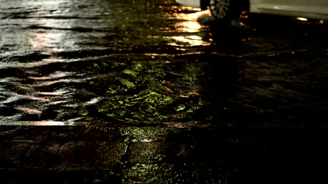 Tráfico-de-la-calle-en-la-lluvia-de-la-noche-con-los-coches-de-inundaciones-como-fondo