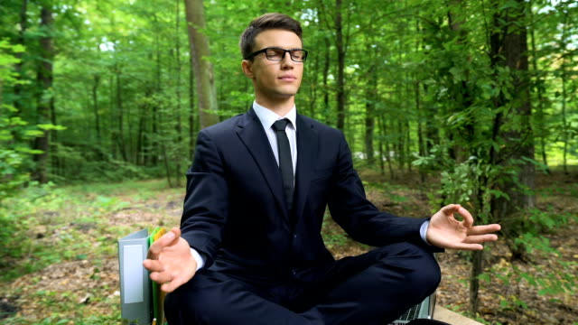 Entspannte-Geschäftsmann-meditieren-im-Lotussitz-im-Freien,-Stressabbau-am-Arbeitsplatz