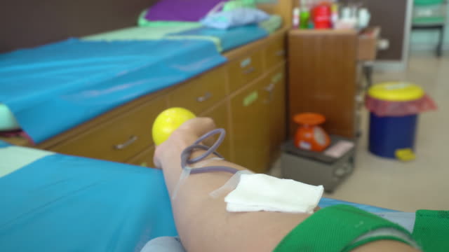 Blood-donation.-Male-hand-of-blood-donor-and-squeezing-rubber-ball-for-bumping-blood-in-hospital.
