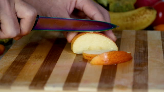 Man-is-slicing-apple-in-slow-motion