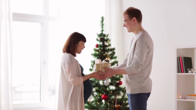 Ehemann-geben-Weihnachtsgeschenk-für-schwangere-Frau