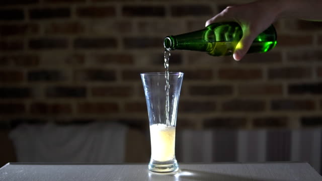 Beer-flowing-from-a-bottle-into-a-glass-beaker