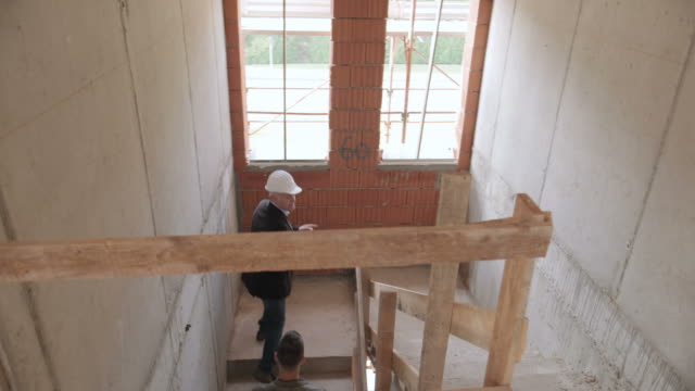 Ingeniero-mostrando-nuevo-apartamento-a-esposa-y-marido-joven