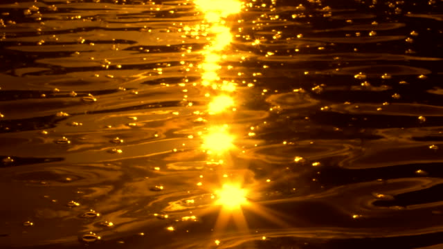 Goldenes-Sonnenlicht-funkeln-auf-wellige-Wasser