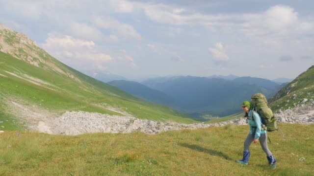Frau-mit-Rucksack-unterwegs-in-den-Bergen-wandern.-Sommer-Klettern-und-Tourismus