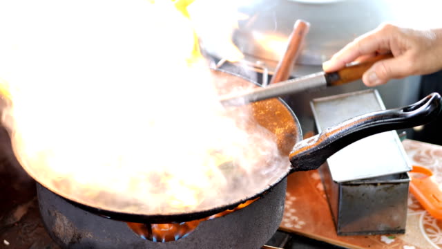 CÁMARA-lenta:-chef-haciendo-de-cerdo-crujiente-con-fuego-de-col-en-una-cacerola-de-cocina