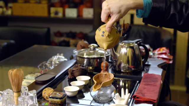 Master-schüttet-Teeblätter-mit-Wasser.-Tee-Zeremonie