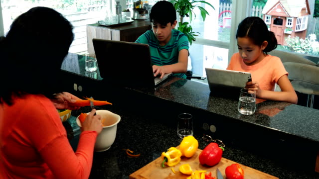 Niños-con-ordenador-portátil-y-tableta-digital-mientras-que-hortalizas-de-corte-madre-4k