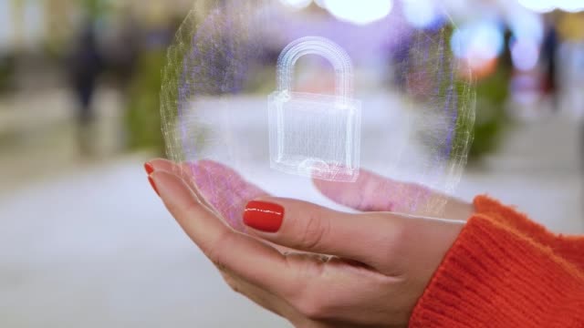 Female-hands-holding-a-conceptual-hologram-with-padlock