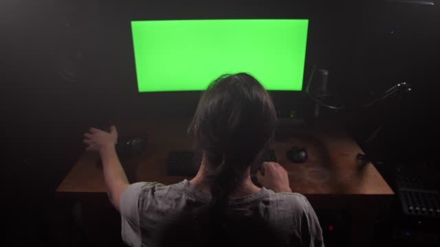 Green-screen.-A-man-looks-at-the-monitor,-then-puts-on-the-headphones.-4K-Slow-Mo