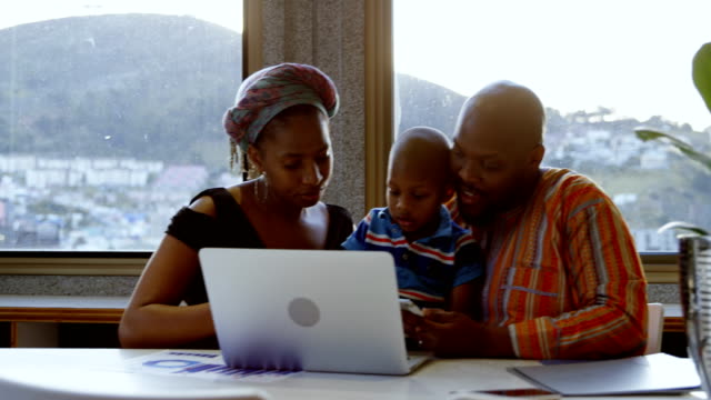 Parents-and-son-using-laptop-and-digital-tablet-at-home-4k