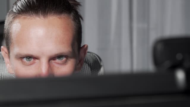 Sliding-cropped-shot-of-a-male-eyes-looking-at-computer-monitor