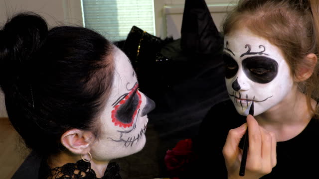Frau-wenden-Halloween-Make-up-für-ihre-Tochter