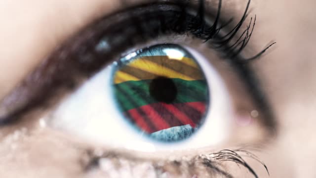 woman-blue-eye-in-close-up-with-the-flag-of-Lithuania-in-iris-with-wind-motion.-video-concept