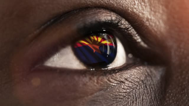 Frau-schwarzes-Auge-in-Nahaufnahme-mit-der-Flagge-von-Arizona-Staat-in-Iris,-vereinigte-Staaten-von-Amerika-mit-Windbewegung.-Videokonzept