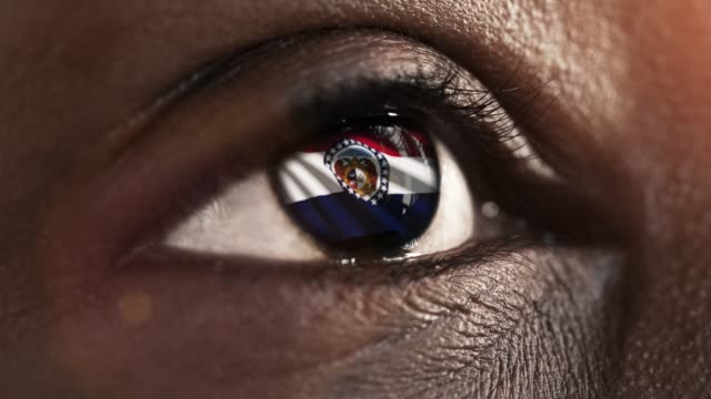 Mujer-ojo-negro-en-primer-plano-con-la-bandera-del-estado-de-Missouri-en-iris,-estados-unidos-de-América-con-movimiento-de-viento.-concepto-de-vídeo