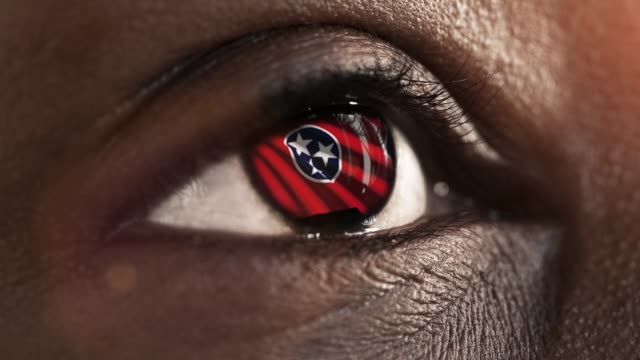 Mujer-ojo-negro-en-primer-plano-con-la-bandera-del-estado-de-Tennessee-en-iris,-estados-unidos-de-América-con-movimiento-de-viento.-concepto-de-vídeo