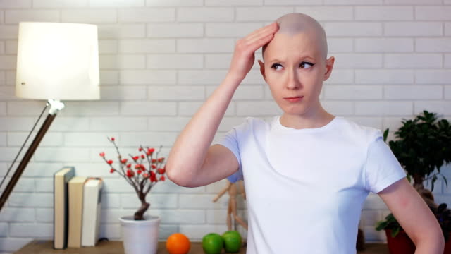 Concerned-woman-in-chemotherapy-looking-in-the-mirror-and-examine-herself